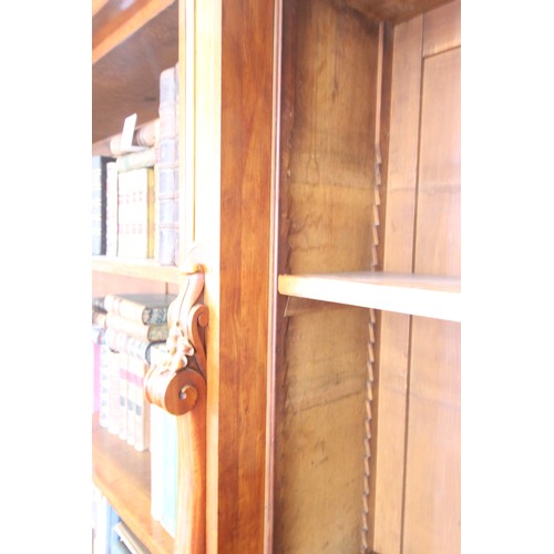 562 - A mid 19th century satin birch breakfront open bookcase, the moulded cornice above the central secti... 