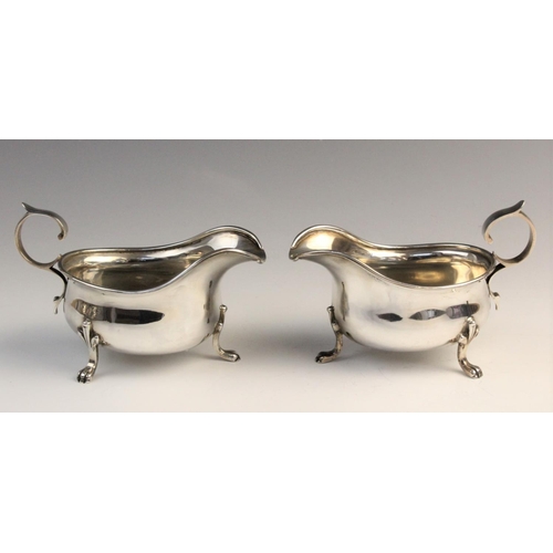 107 - A pair of George V silver sauceboats by M Beaver Ltd, Sheffield 1936, each of typical form with scro... 