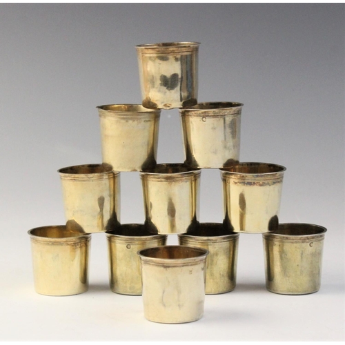 108 - A set of ten early 19th century French silver gilt tots, each of plain polished cylindrical form wit... 