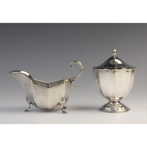 112 - An Edwardian silver sauce boat by Horace Woodward & Co Ltd, London 1910, of faceted form with scroll... 