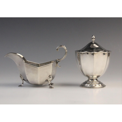 112 - An Edwardian silver sauce boat by Horace Woodward & Co Ltd, London 1910, of faceted form with scroll... 