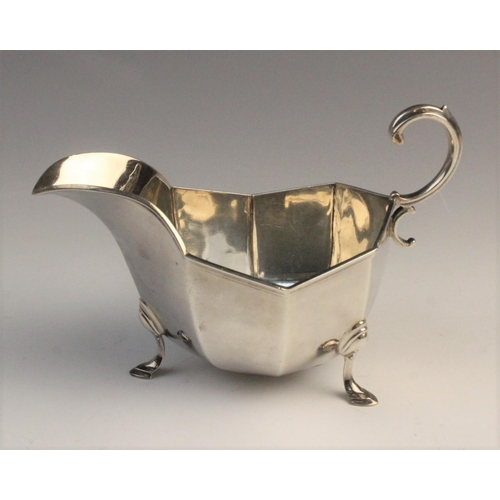 112 - An Edwardian silver sauce boat by Horace Woodward & Co Ltd, London 1910, of faceted form with scroll... 