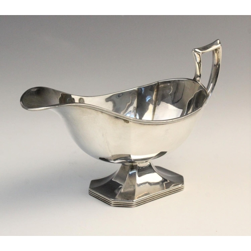 12 - A George V silver sauce boat by Harrison Brothers & Howson, London 1911, of faceted form on raised o... 