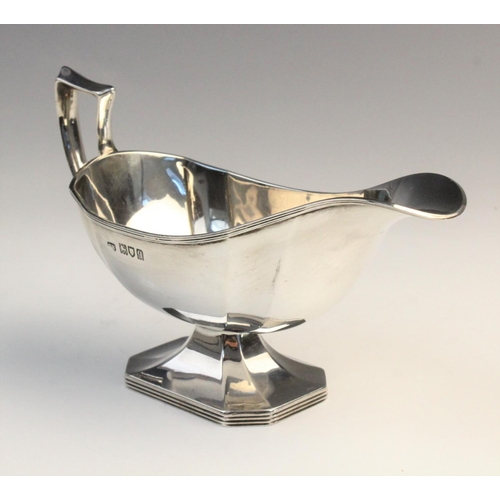 12 - A George V silver sauce boat by Harrison Brothers & Howson, London 1911, of faceted form on raised o... 