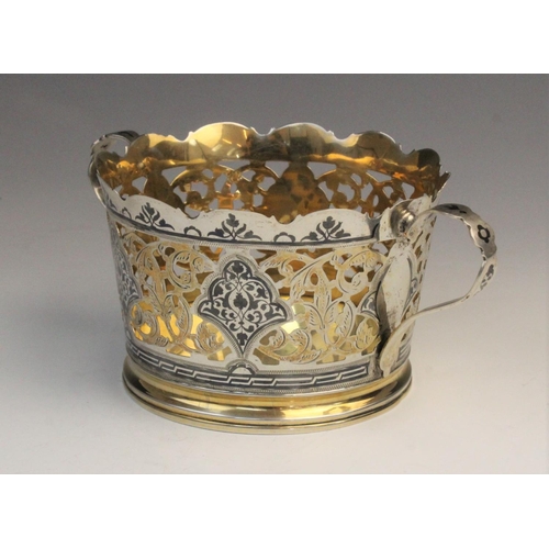 50 - A Russian silver gilt and niello twin-handled wine coaster, of tapering form with pierced foliate de... 