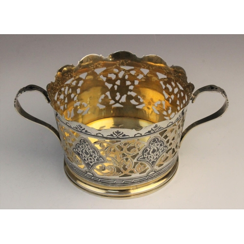 50 - A Russian silver gilt and niello twin-handled wine coaster, of tapering form with pierced foliate de... 