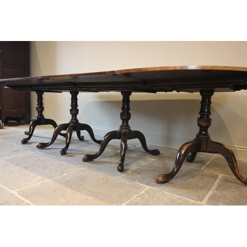 741 - A George III style four pillar mahogany dining table, early 20th century, the segmentally veneered a... 