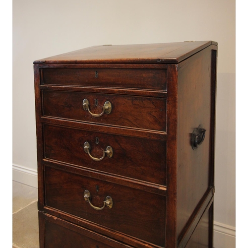 743 - A George III teak campaign style clerk’s desk, the hinged canted slope above three graduated drawers... 