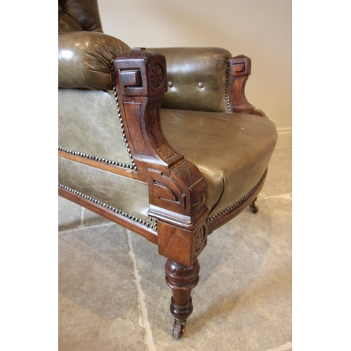 754 - A late Victorian green leather and walnut drawing room chair, the button back over padded arms exten... 