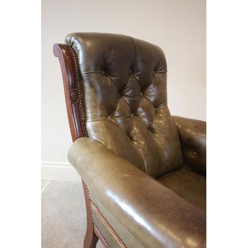 754 - A late Victorian green leather and walnut drawing room chair, the button back over padded arms exten... 