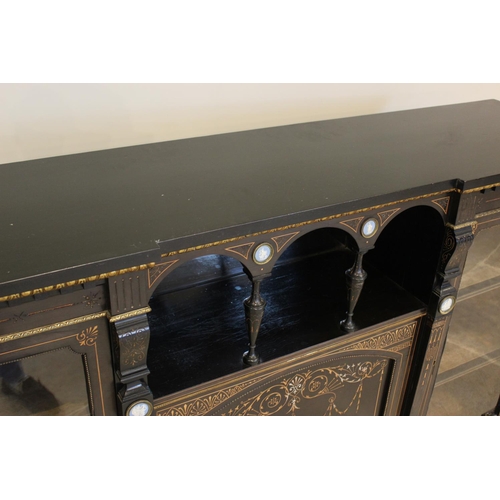 755 - A late Victorian ebonised Aesthetic movement inverted breakfront credenza, having a central arcaded ... 