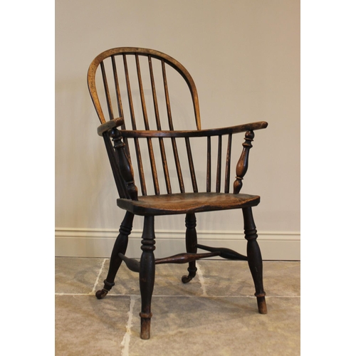 758 - An early 19th century elm and ash hoop back Windsor chair, the shaped elm seat raised upon turned le... 