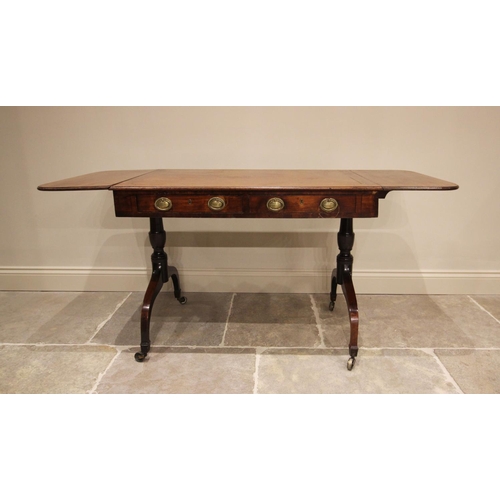 765 - An early 19th century mahogany sofa table, the rectangular top above two drawers, terminating with t... 