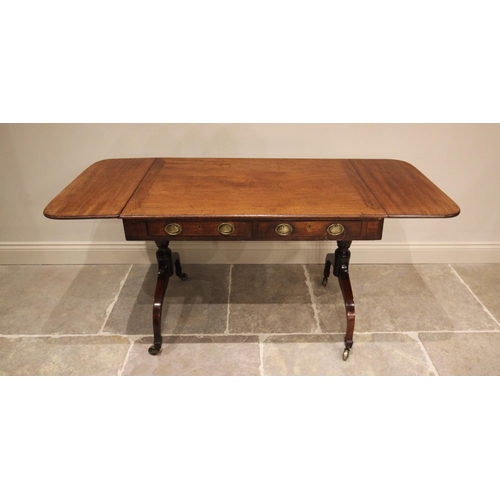 765 - An early 19th century mahogany sofa table, the rectangular top above two drawers, terminating with t... 