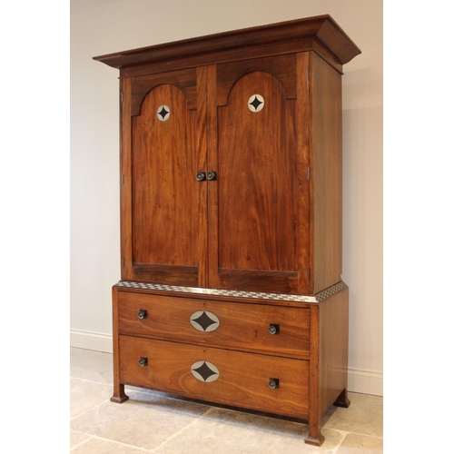 797 - An early 20th century mahogany Arts & Crafts linen press, in the manner of Ambrose Heal, the cavetto... 