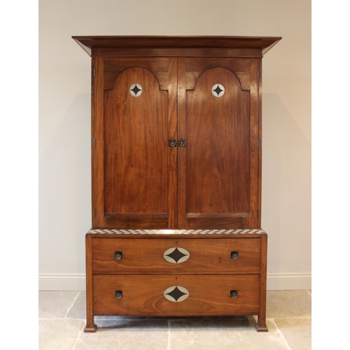 797 - An early 20th century mahogany Arts & Crafts linen press, in the manner of Ambrose Heal, the cavetto... 