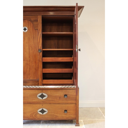 797 - An early 20th century mahogany Arts & Crafts linen press, in the manner of Ambrose Heal, the cavetto... 