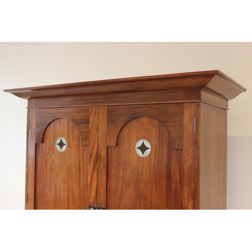 797 - An early 20th century mahogany Arts & Crafts linen press, in the manner of Ambrose Heal, the cavetto... 