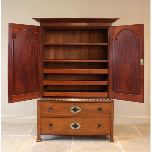 797 - An early 20th century mahogany Arts & Crafts linen press, in the manner of Ambrose Heal, the cavetto... 