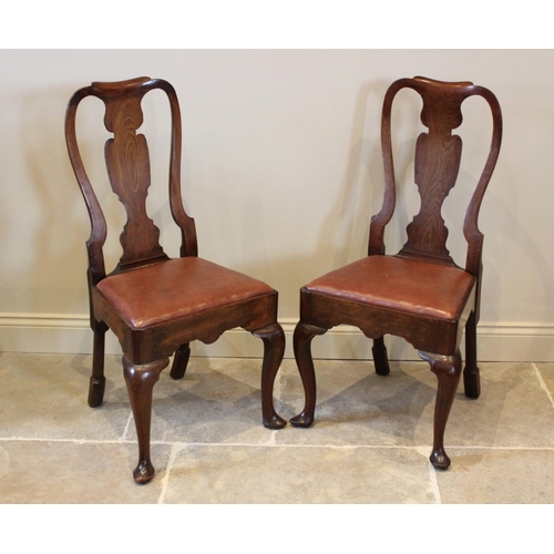 678 - A pair of George I walnut side chairs, each with a vase shaped splat over a drop in upholstered seat... 