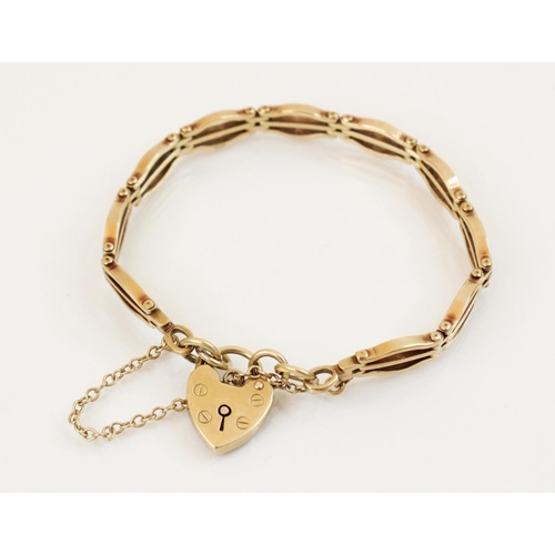 109 - A 9ct gold gate link bracelet, 18cm long, suspending a 9ct gold heart-shaped padlock fastener, 14mm ... 