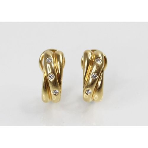 118 - A pair of 18ct gold diamond set earrings, each comprising three brilliant cut diamonds weighing appr... 