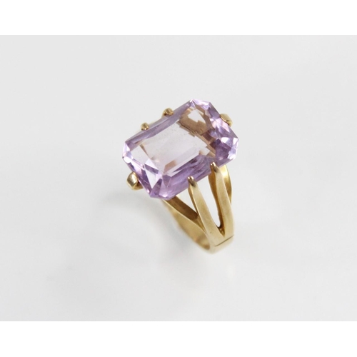 145 - An amethyst set 9ct gold dress ring, the central rectangular mixed cut stone with canted corners, (m... 