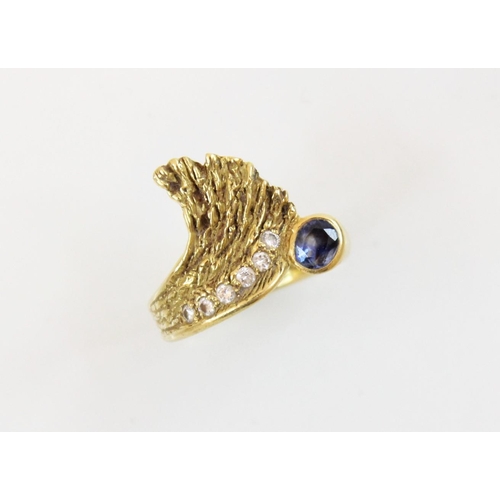 151 - A sapphire and diamond 18ct gold ring, designed as an open wing, set with an oval mixed cut sapphire... 