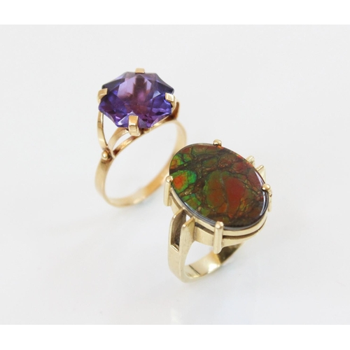 154 - An ammolite triplet ring, the central oval ammolite panel (measuring 17mm x 12mm), claw set to pierc... 