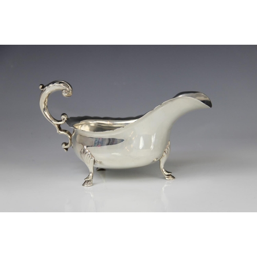 19 - A George V silver sauce boat by Josiah Williams & Co, London 1922, of typical form with shaped rim a... 