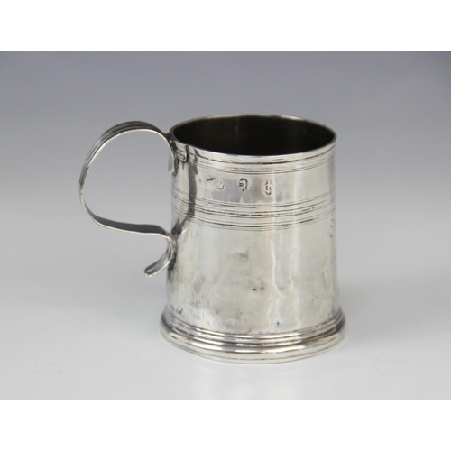 23 - A Queen Anne silver mug, of tapered cylindrical form on raised circular foot with simple loop handle... 