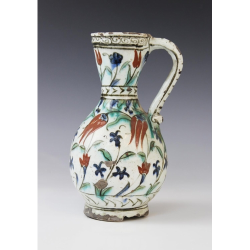 241 - An Ottoman Empire Turkish polychrome pottery jug, of pear shape with attached handle and flared neck... 