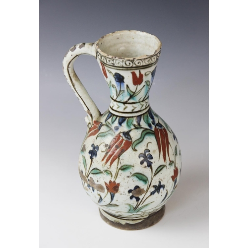 241 - An Ottoman Empire Turkish polychrome pottery jug, of pear shape with attached handle and flared neck... 