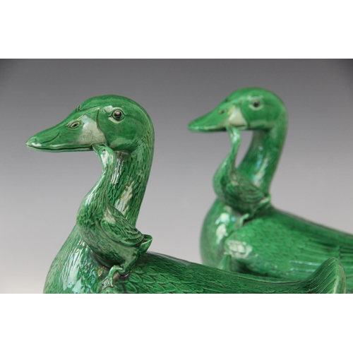 272 - A pair of Chinese porcelain green glazed ducks, early 20th century, each modelled with two ducklings... 