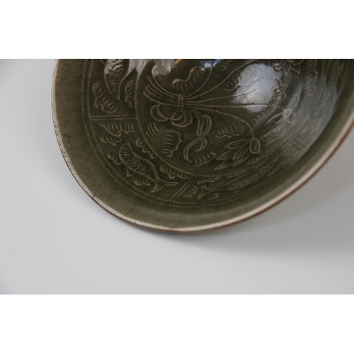 277 - A Chinese Yaozhou ware celadon bowl, of circular form and internally decorated with lotus blooms and... 