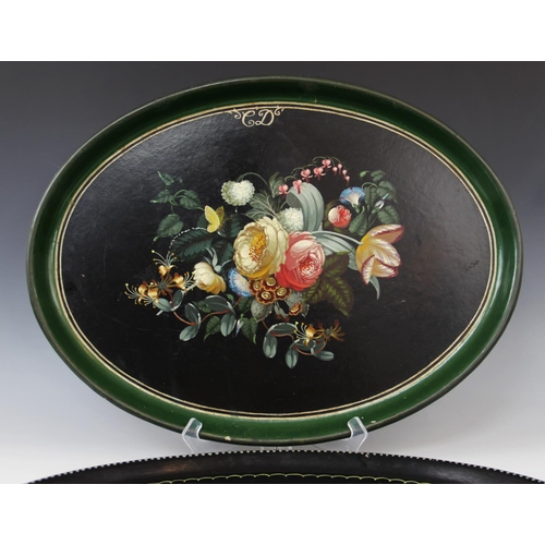 349 - A Victorian black lacquered papier mache tray, mid 19th century, of oval form, hand painted with flo... 