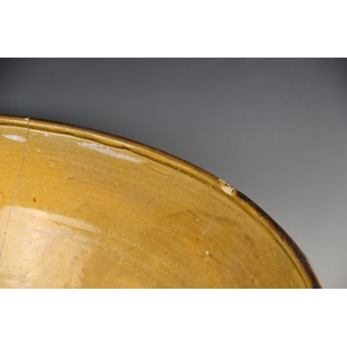 413 - A slipware cream bowl of country house proportions, 19th century, of conical form with loop handles ... 