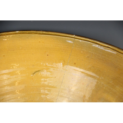 413 - A slipware cream bowl of country house proportions, 19th century, of conical form with loop handles ... 