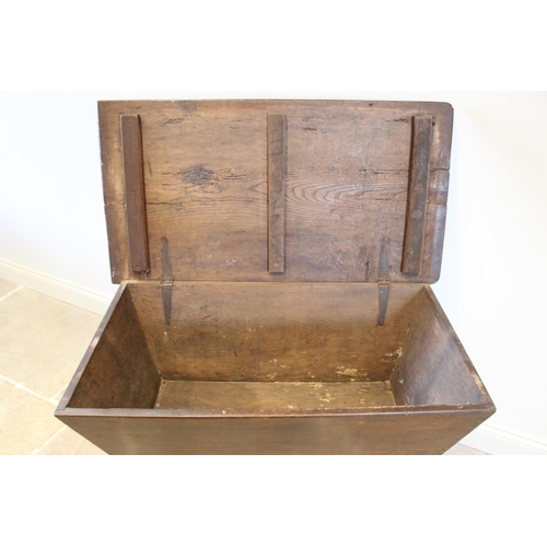 594 - An 18th century elm dough bin, of typical tapering form with a hinged cover, upon an associated stan... 