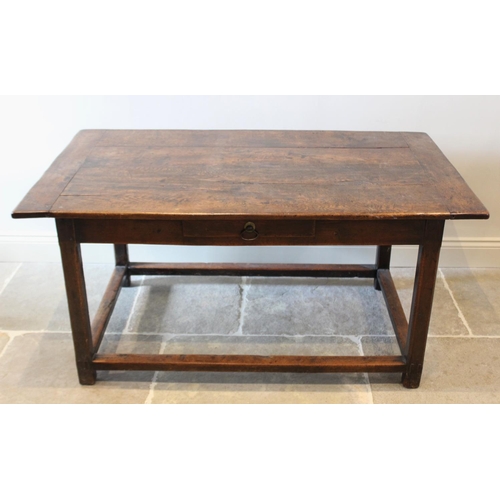 595 - An early 18th century oak kitchen table, the cleated plank top raised upon chamfered legs of square,... 