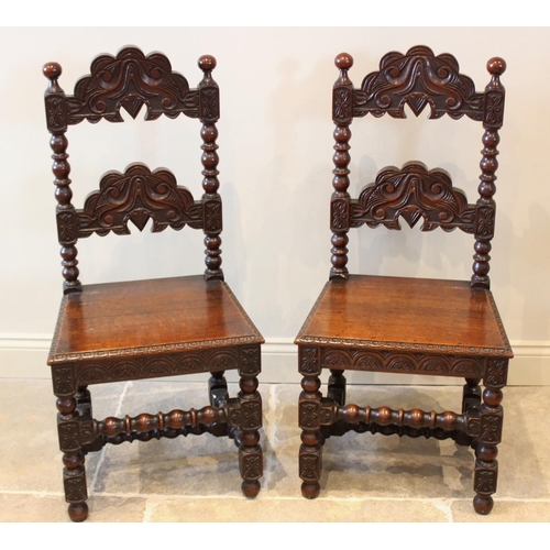 598 - A pair of 17th century style oak Derbyshire side chairs, 20th century, each with a carved rung back ... 