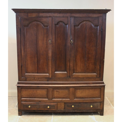 600 - An 18th century oak livery cupboard, the moulded cornice above a pair of fielded panelled cupboard d... 