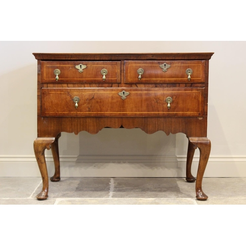 603 - An early 18th century figured walnut side table/low boy, the quarter veneered and cross banded recta... 