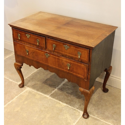 603 - An early 18th century figured walnut side table/low boy, the quarter veneered and cross banded recta... 