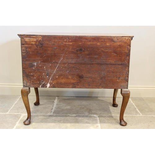 603 - An early 18th century figured walnut side table/low boy, the quarter veneered and cross banded recta... 