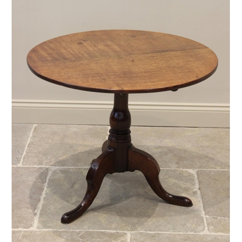 616 - A George III oak tripod table, the circular top raised upon a ring turned baluster column, extending... 