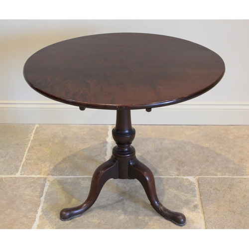 620 - A George III mahogany tripod table, the circular tilt top raised upon a ring turned baluster pedesta... 