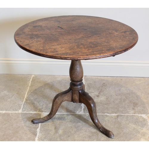 627 - A George III oak tripod table, the circular top raised upon a baluster column extending to three dow... 