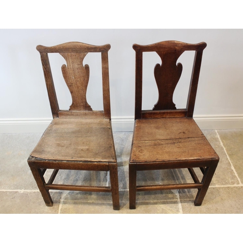 632 - A set of six George III oak country chairs, each with a cupids bow top rail above a vase shaped spla... 