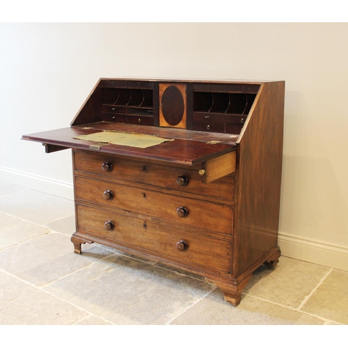 636 - A George III mahogany bureau, the fall front opening to a compartmentalised interior, over two short... 